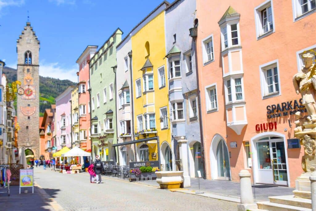 Multicolored buildings line a cobbled street in Northern Italy